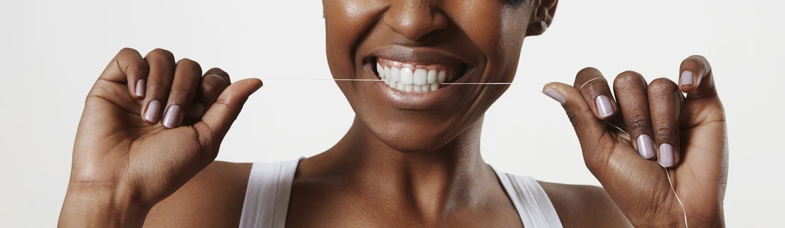 Dentist Waukesha WI Smiling Woman Flossing Her Teeth